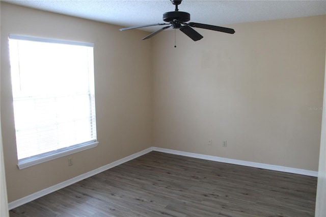 spare room with a textured ceiling, baseboards, a ceiling fan, and wood finished floors