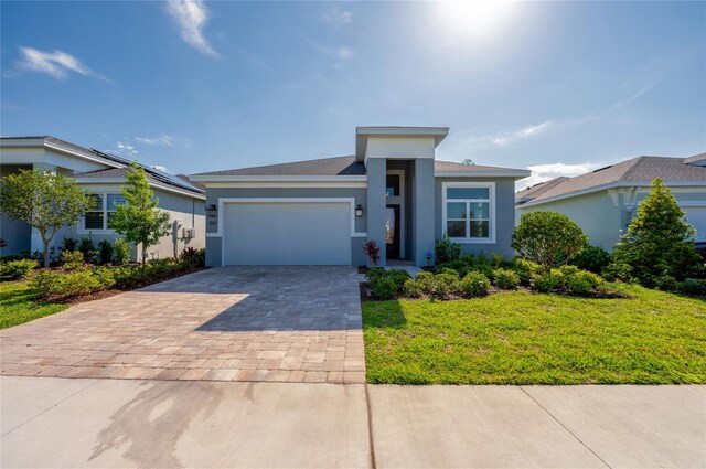 887 Lake Hill Way, Deland, FL 32724 - prairie-style house featuring an attached garage, stucco siding, decorative driveway, and a front yard