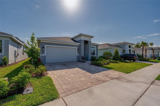 887 Lake Hill Way, Deland, FL 32724 - view of front of house featuring a garage, stucco siding, a front lawn, and decorative driveway