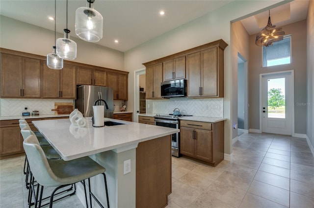 887 Lake Hill Way, Deland, FL 32724 - kitchen featuring a breakfast bar area, a sink, pendant lighting, appliances with stainless steel finishes, and tasteful backsplash