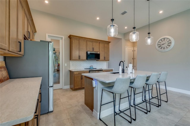 887 Lake Hill Way, Deland, FL 32724 - kitchen with a breakfast bar, a sink, brown cabinetry, appliances with stainless steel finishes, and tasteful backsplash