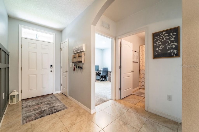 343 Lazio Cir, Debary, FL 32713 - foyer with arched walkways, light tile patterned floors, and baseboards