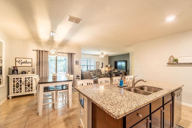 343 Lazio Cir, Debary, FL 32713 - kitchen featuring a sink, a kitchen island with sink, baseboards, light tile patterned floors, and light stone counters