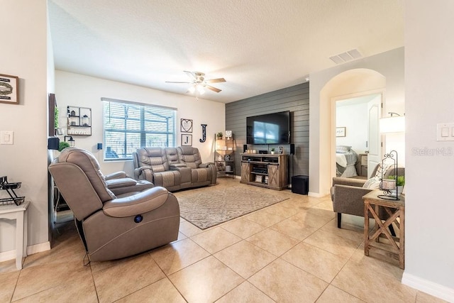 343 Lazio Cir, Debary, FL 32713 - living room featuring ceiling fan, an accent wall, baseboards, light tile patterned floors, and wooden walls