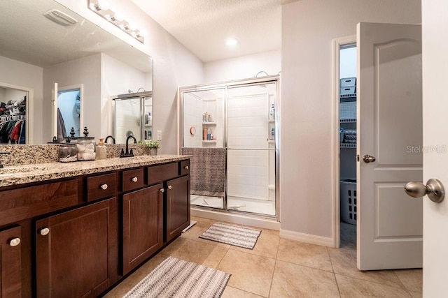 343 Lazio Cir, Debary, FL 32713 - full bathroom with a shower stall, a walk in closet, tile patterned flooring, double vanity, and baseboards
