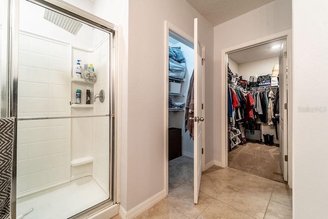 343 Lazio Cir, Debary, FL 32713 - full bathroom with a stall shower, a walk in closet, tile patterned floors, and a textured ceiling