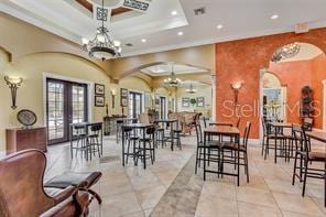 343 Lazio Cir, Debary, FL 32713 - tiled dining space with recessed lighting, arched walkways, french doors, a raised ceiling, and a chandelier