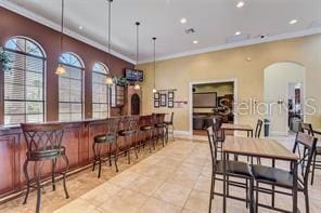 343 Lazio Cir, Debary, FL 32713 - dining room with arched walkways, crown molding, recessed lighting, a dry bar, and light tile patterned flooring