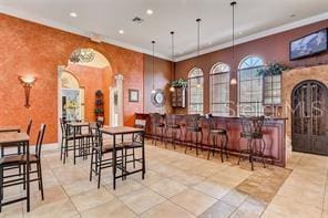 343 Lazio Cir, Debary, FL 32713 - dining area with arched walkways, recessed lighting, a bar, and crown molding
