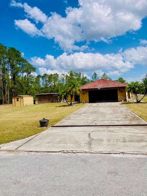 view of front of property with a garage, driveway, a front yard, and a tile roof