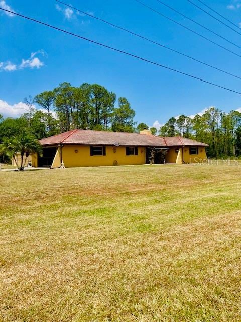 back of house featuring a lawn