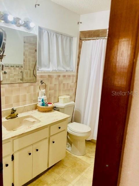 full bathroom with a shower with curtain, a textured ceiling, tile patterned flooring, vanity, and toilet
