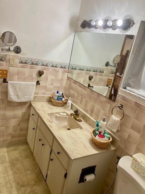 bathroom featuring a shower with curtain, tile walls, tile patterned flooring, vanity, and toilet