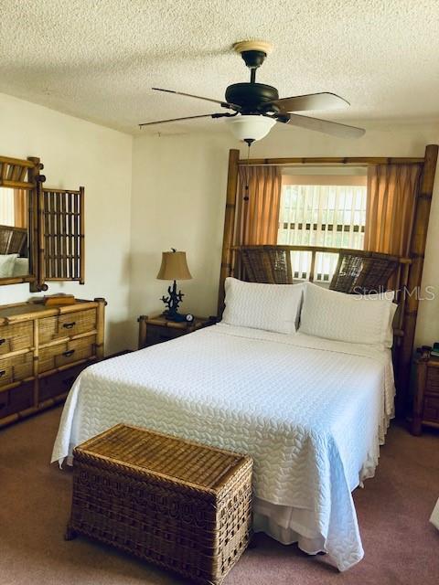 bedroom featuring a textured ceiling, carpet, and ceiling fan