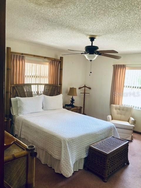 bedroom with ceiling fan, carpet flooring, and a textured ceiling