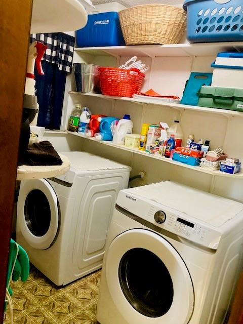 washroom with independent washer and dryer and laundry area