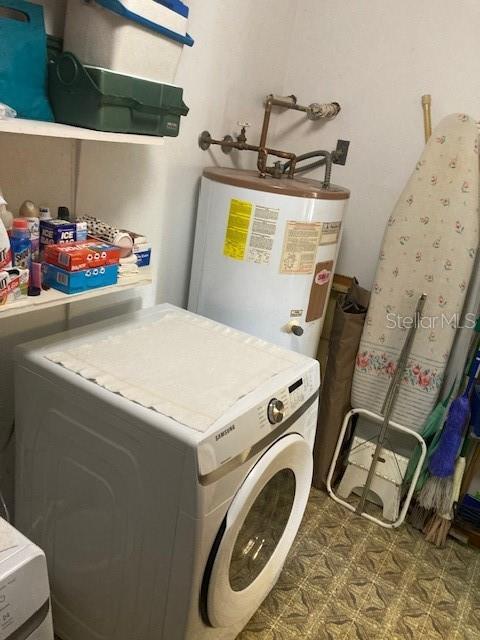 laundry room with laundry area, washer / dryer, and gas water heater