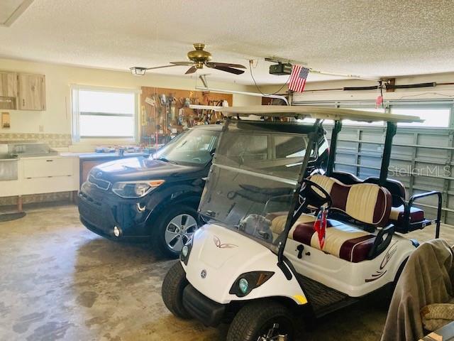 garage with ceiling fan and a garage door opener