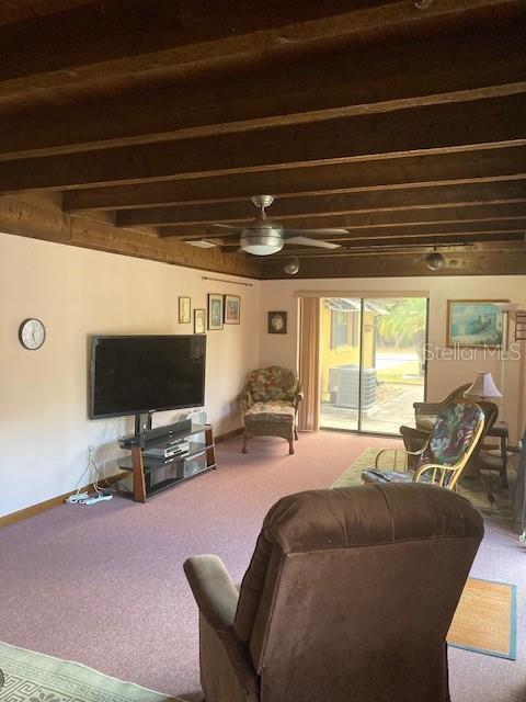 carpeted living room with ceiling fan and baseboards