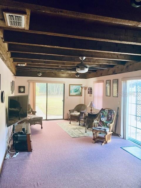 interior space featuring carpet floors, a ceiling fan, beamed ceiling, and visible vents