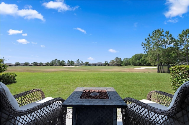 view of yard with an outdoor fire pit and golf course view