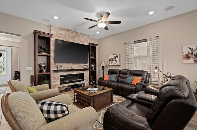 living area with a large fireplace, ceiling fan, and recessed lighting