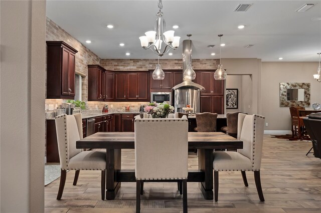 dining room with recessed lighting, an inviting chandelier, visible vents, and light wood-type flooring