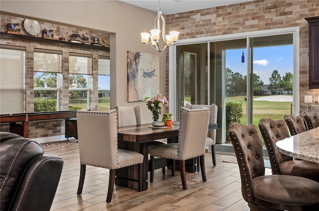 dining area featuring light wood-type flooring and a notable chandelier