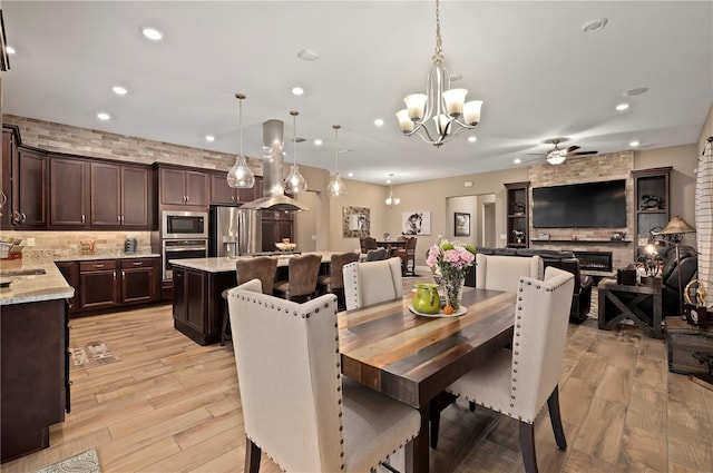 dining room featuring recessed lighting, ceiling fan with notable chandelier, and light wood finished floors