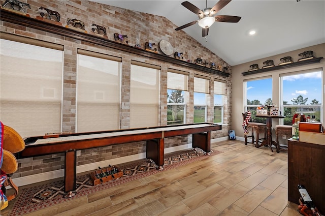 playroom with a healthy amount of sunlight, baseboards, a ceiling fan, and vaulted ceiling