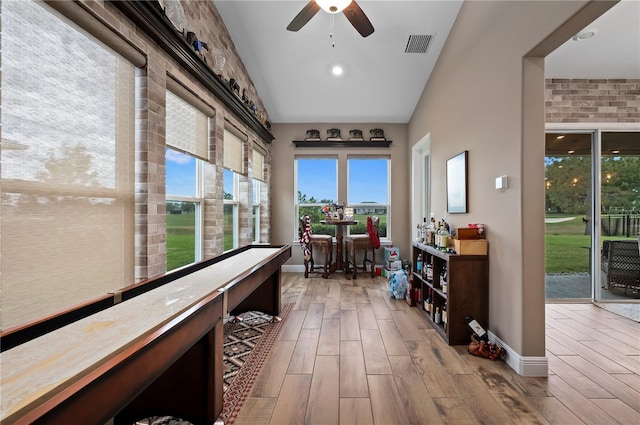sunroom featuring baseboards, wood finished floors, and visible vents