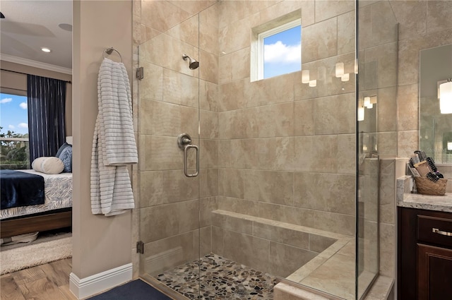 ensuite bathroom featuring a shower stall, ornamental molding, wood finished floors, and ensuite bath