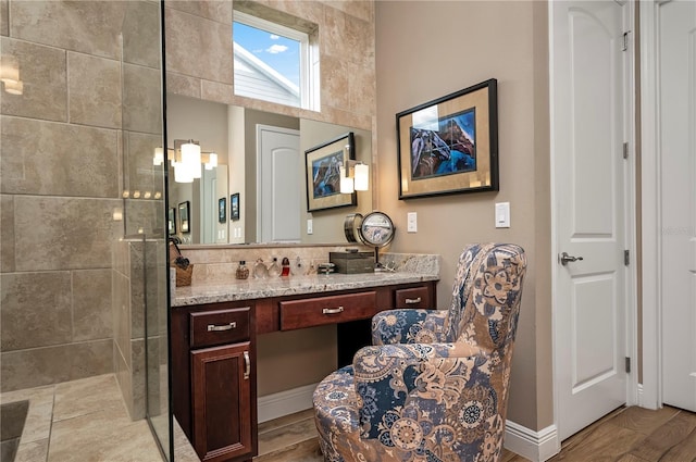 full bath with baseboards, tasteful backsplash, tiled shower, and vanity