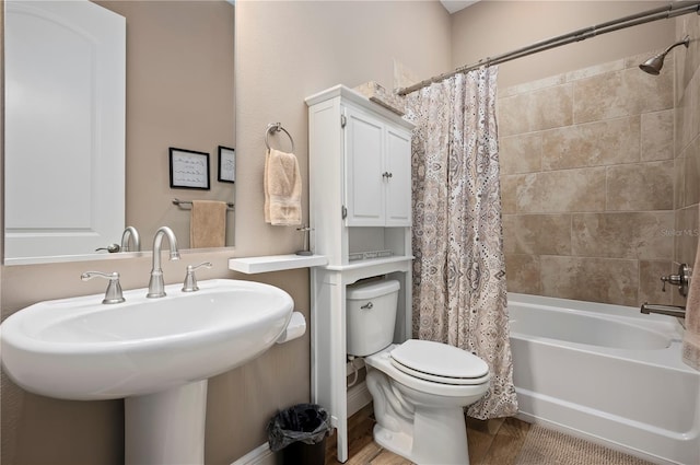 full bath with a sink, shower / tub combo, and toilet