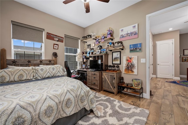 bedroom with baseboards, ceiling fan, and light wood-style flooring
