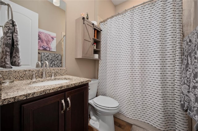 bathroom with a shower with shower curtain, toilet, wood finished floors, and vanity
