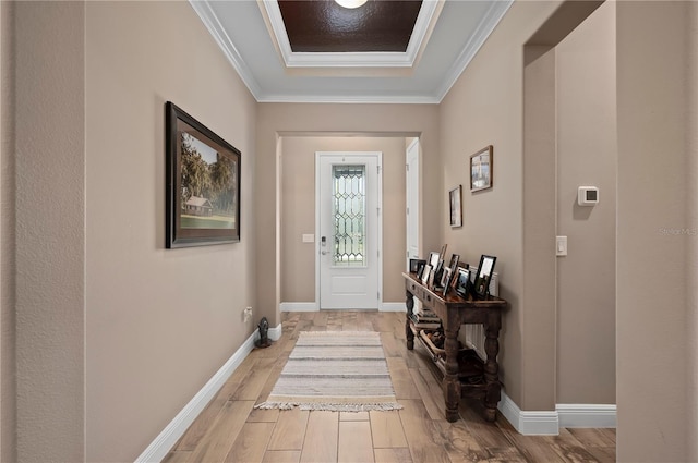doorway featuring light wood-style floors, baseboards, and ornamental molding