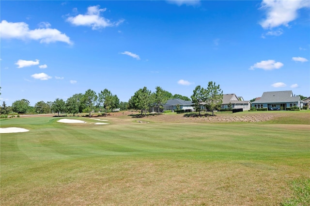 surrounding community with a lawn, view of golf course, and a residential view
