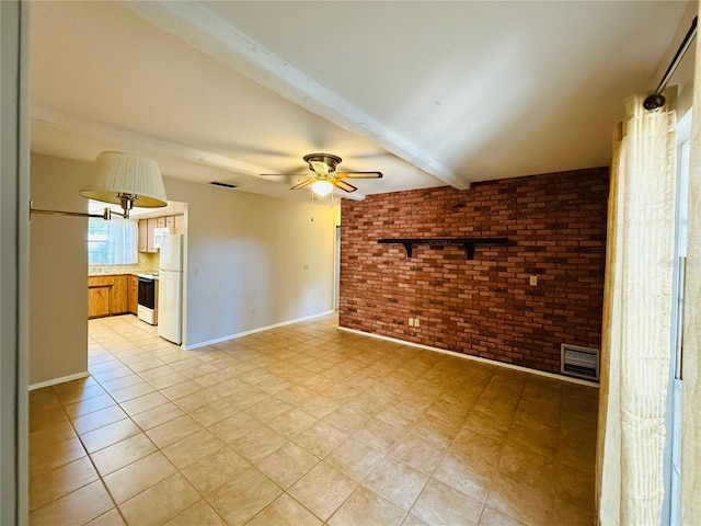 spare room with a ceiling fan, beam ceiling, brick wall, visible vents, and baseboards