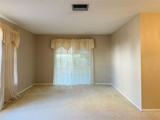 unfurnished room with light carpet, baseboards, and visible vents