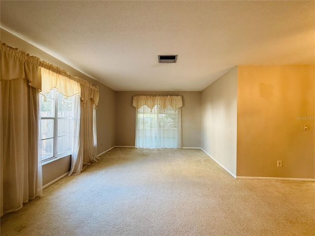 carpeted spare room with baseboards and visible vents