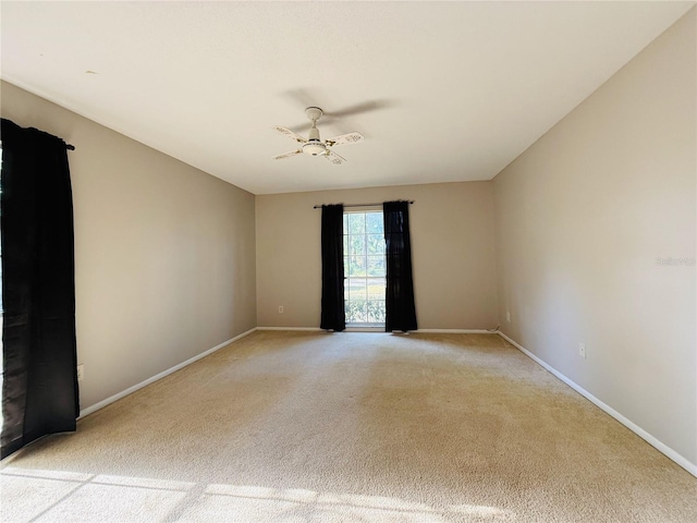 spare room with light colored carpet and baseboards