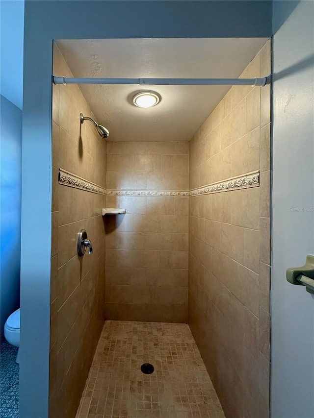 bathroom featuring toilet and a stall shower