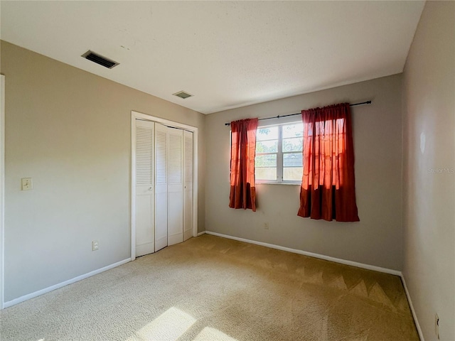 unfurnished bedroom featuring baseboards, visible vents, and carpet floors