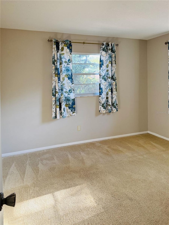 empty room featuring baseboards and carpet floors