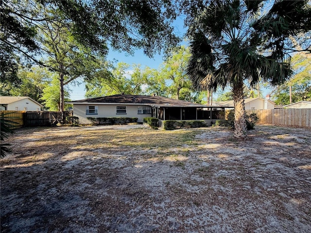 back of property featuring a sunroom and a fenced backyard