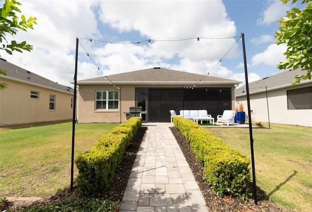 back of house featuring a yard, a patio area, and stucco siding
