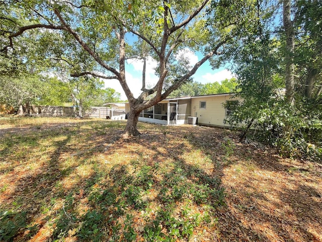 2332 Hadley St, Deltona, FL 32738 - view of yard with a sunroom, central air condition unit, and fence