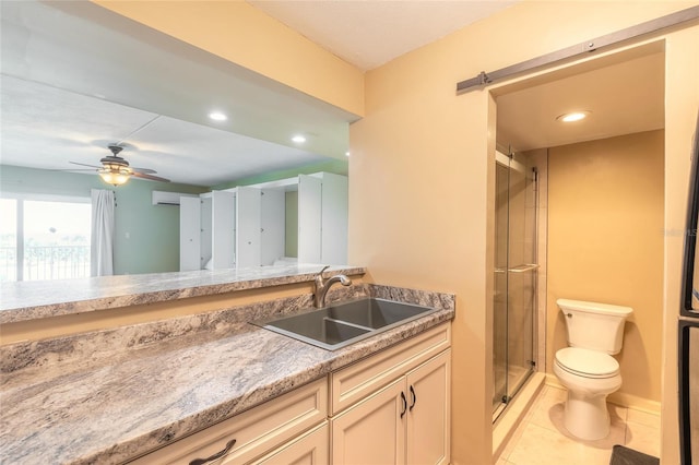 bathroom featuring toilet, vanity, ceiling fan, tile patterned flooring, and a shower stall