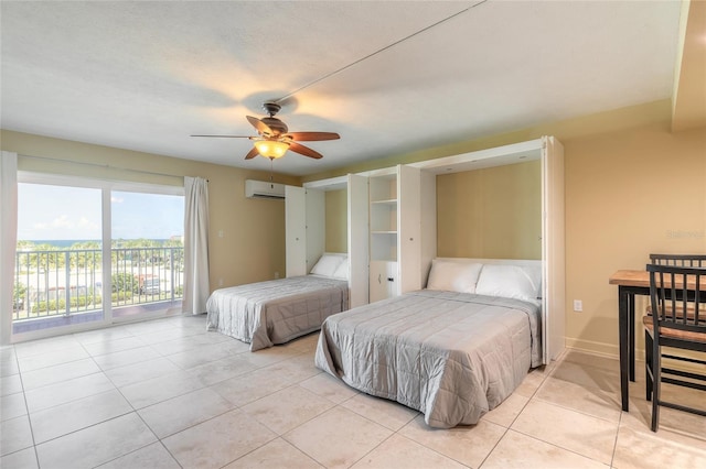 bedroom with a ceiling fan, a wall unit AC, light tile patterned floors, and access to exterior